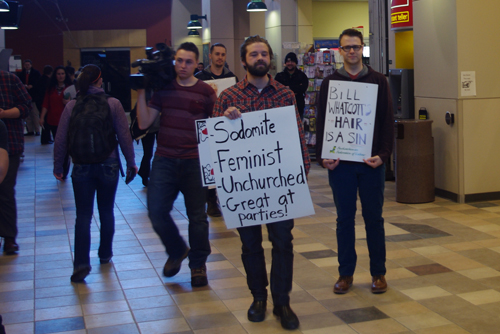 Counter-protesters walk over to Whatcott's display.